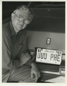 Marshall Nirenberg with a personalized license plate displaying the first codon he discovered (UUU).